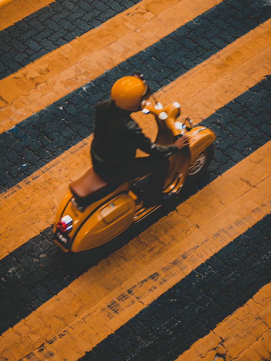malaysia man riding on yellow motor scooter on striped yellow lines road